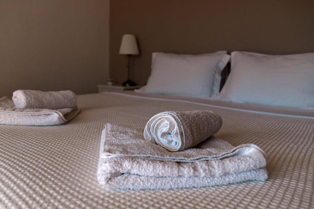 a bed with two towels sitting on top of it at Bozikis House! A cosy apartment in the city centre in Skiathos