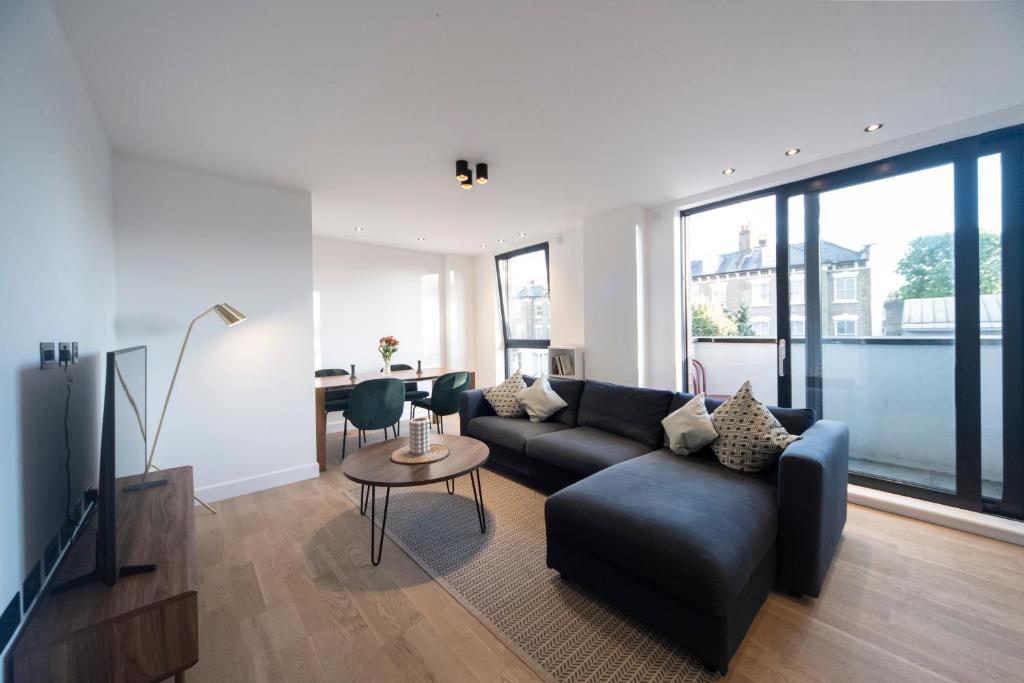 a living room with a couch and a table at Bright & Quiet - Spacious Apt with Balcony & Lift in London