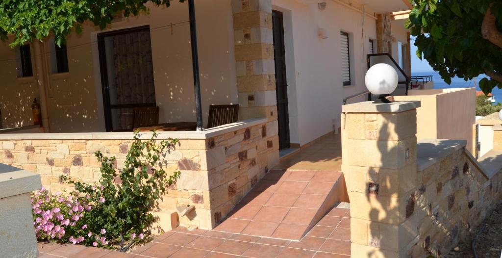 a house with a retaining wall and a fence at Romantica Apartments in Falasarna