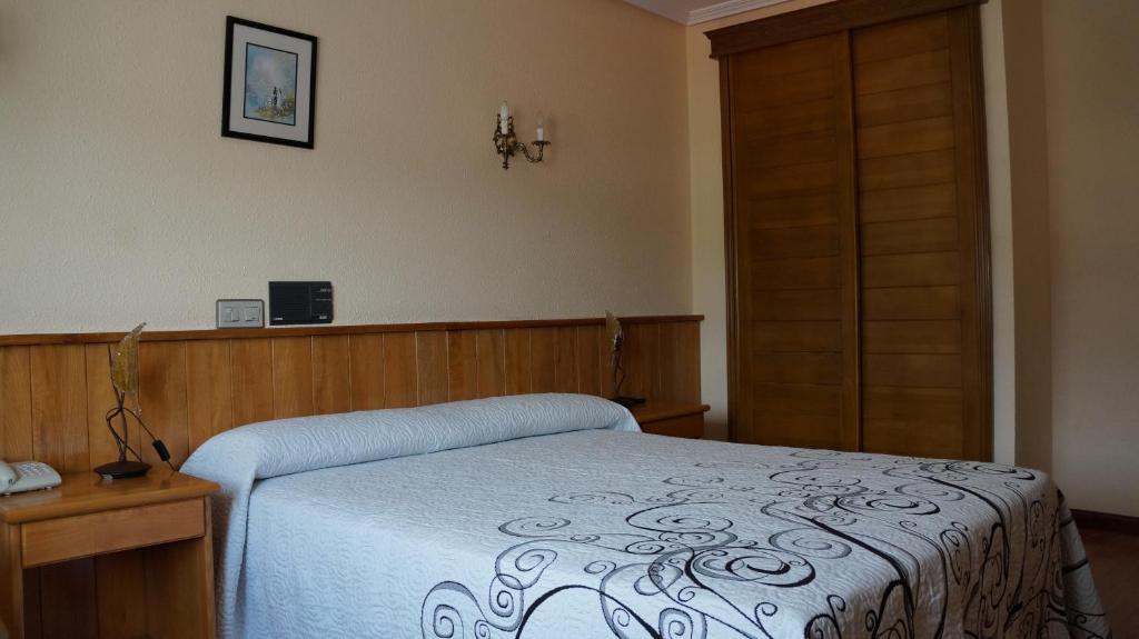 Schlafzimmer mit einem Bett und einer Holztür in der Unterkunft Hotel Larry in Cee