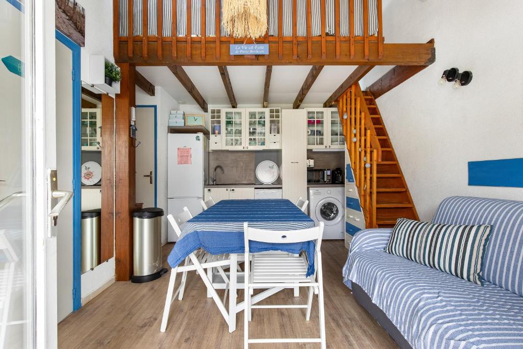 eine Küche und ein Esszimmer mit einem Tisch und einem Sofa in der Unterkunft La Casa di Benedetta - 2min à pied de la plage in Portiragnes