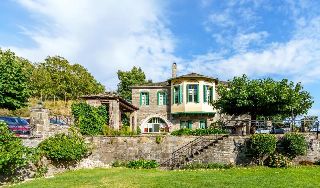 a house on a hill with a stone wall at Timfea Chalet in Tsepelovo