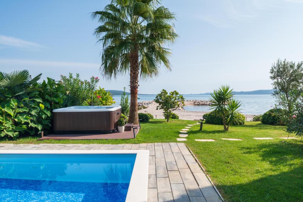 basen przy plaży z palmą w obiekcie Suncana Villa Sukosan w Sukošanie