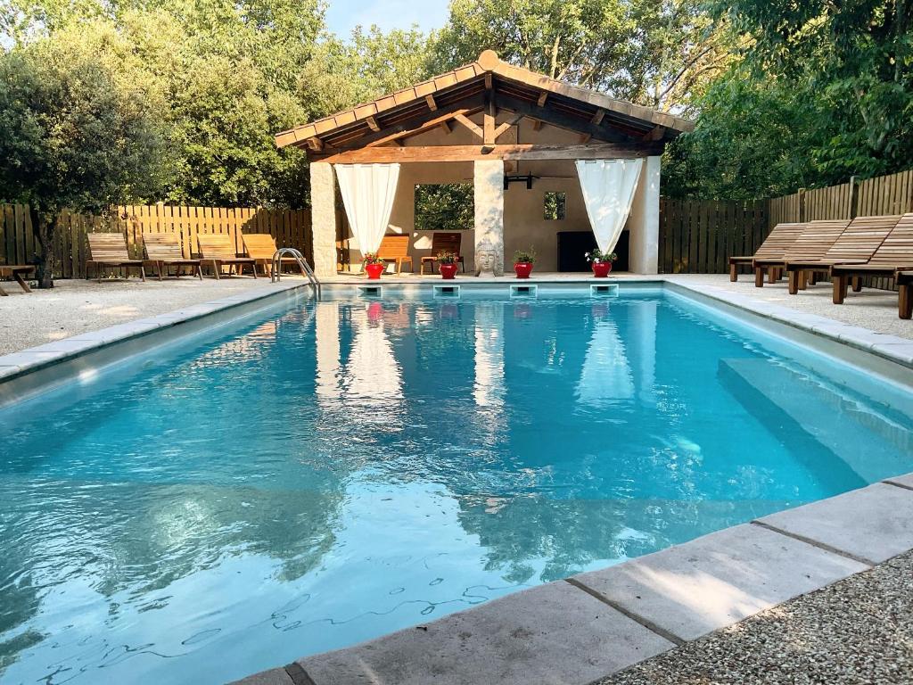 a swimming pool with a gazebo in a backyard at Les Chalets de Labeaume in Labeaume