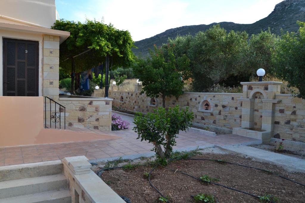a stone retaining wall in front of a house at Romantica Apartments in Falasarna