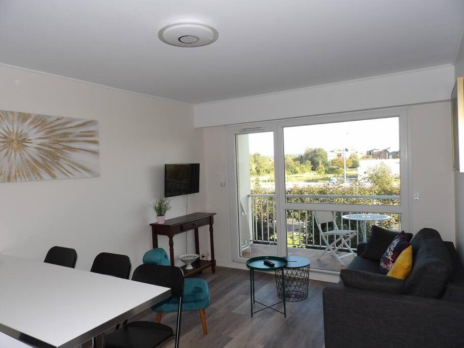 - un salon avec un canapé et une table dans l'établissement Charmant T2 tout confort Cabourg, à Cabourg