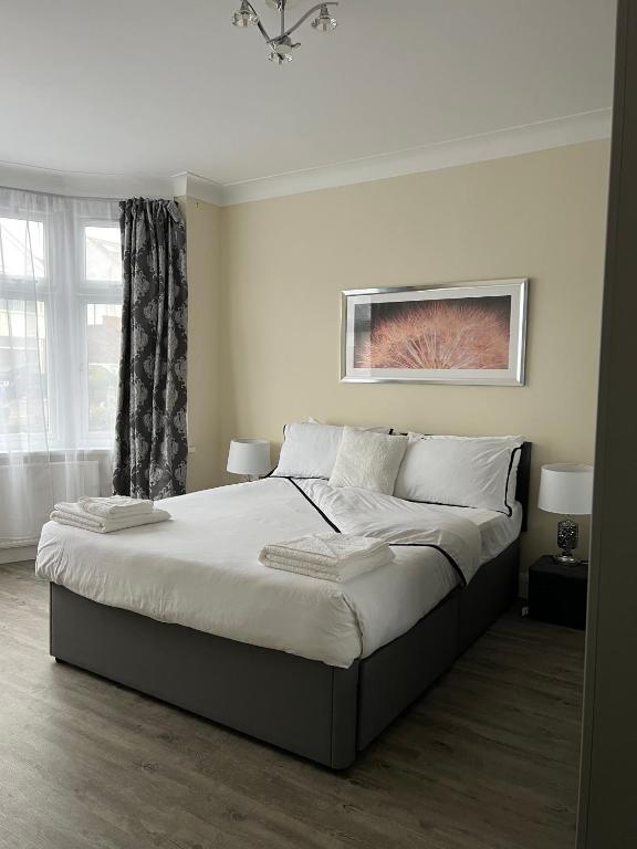 a bedroom with a large bed and a window at 4 Bedroom holiday home in Woodford