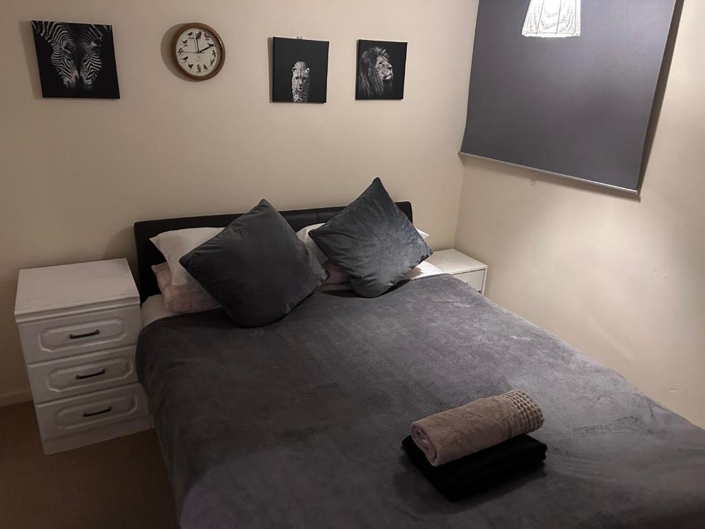 a bedroom with a bed and a clock on the wall at Genesis place in Basildon