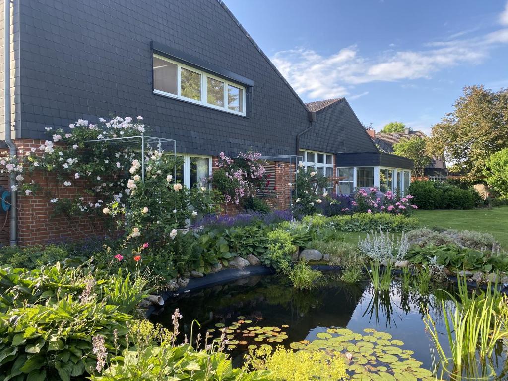 un jardín con un estanque frente a una casa en Landhaus Bleckede - App 1 Bleckede en Bleckede