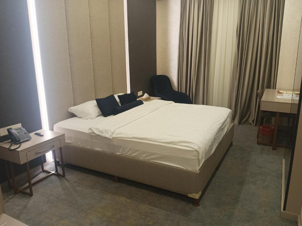 a bedroom with a bed and a chair and a desk at Darin Plaza Hotel in Erbil