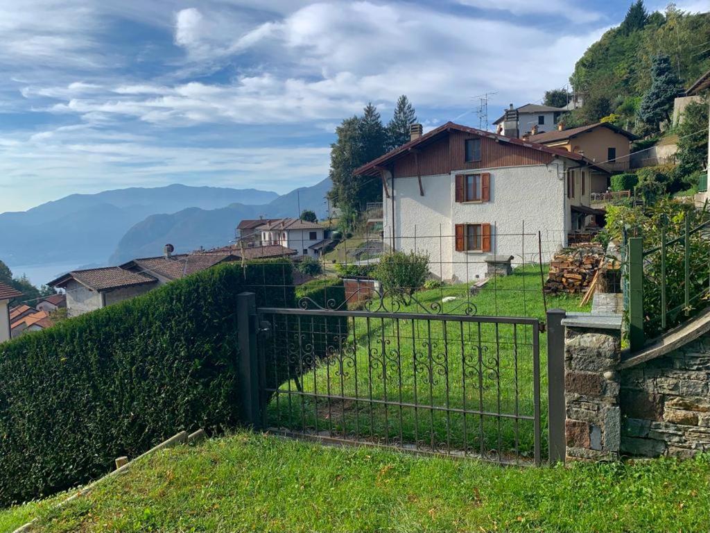 einen Zaun vor einem Dorf mit einem Haus in der Unterkunft Casa Savina - stupenda vista lago e monti in Plesio