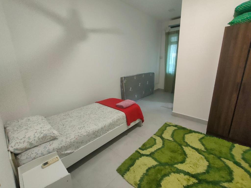 um quarto com uma cama e um tapete verde em Sierra Hill Homestay 