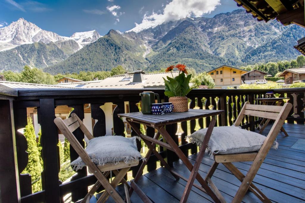 een tafel en stoelen op een terras met bergen bij Apartment Amethyste 2 Bedrooms with Free Parking in Les Houches
