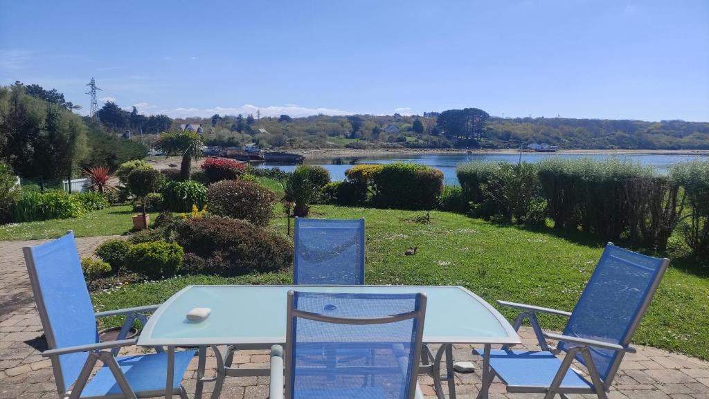 d'une table et de chaises avec vue sur la rivière. dans l'établissement vue mer de l'autre coté du jardin, à Crozon