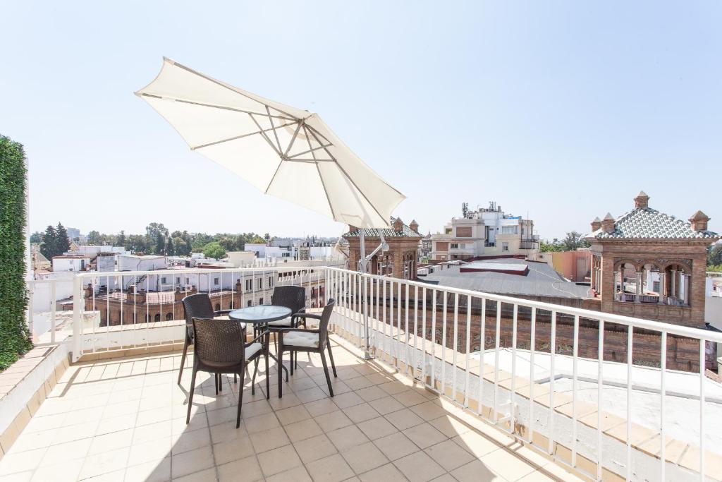 a patio area with chairs, tables, and umbrellas at Apartamentos Diaber Edificio Constitución in Seville