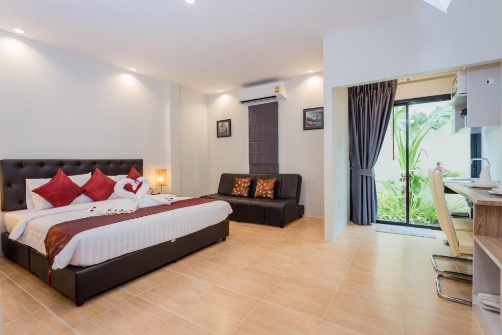 a bedroom with a bed and a couch in it at Journey Residence Phuket in Bang Tao Beach