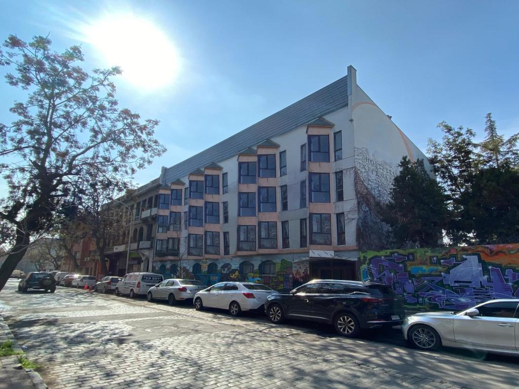 a building with cars parked in a parking lot at Hostel Cienfuegos in Santiago