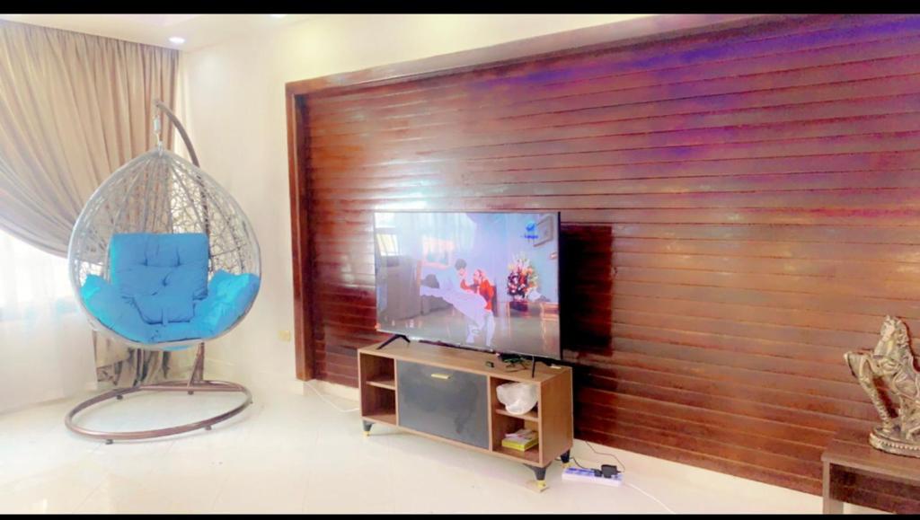 Il comprend un salon doté d'une télévision à écran plat et d'une chaise bleue. dans l'établissement شقه على كورنيش المعادي, au Caire
