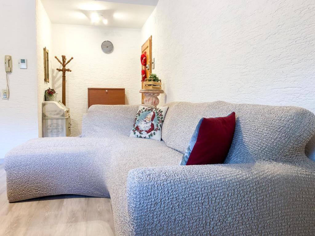 ein Schlafzimmer mit einem blauen Sofa und einem roten Kissen in der Unterkunft Spazioso Angolo di Paradiso - Residence Erika (TN) in San Valentino