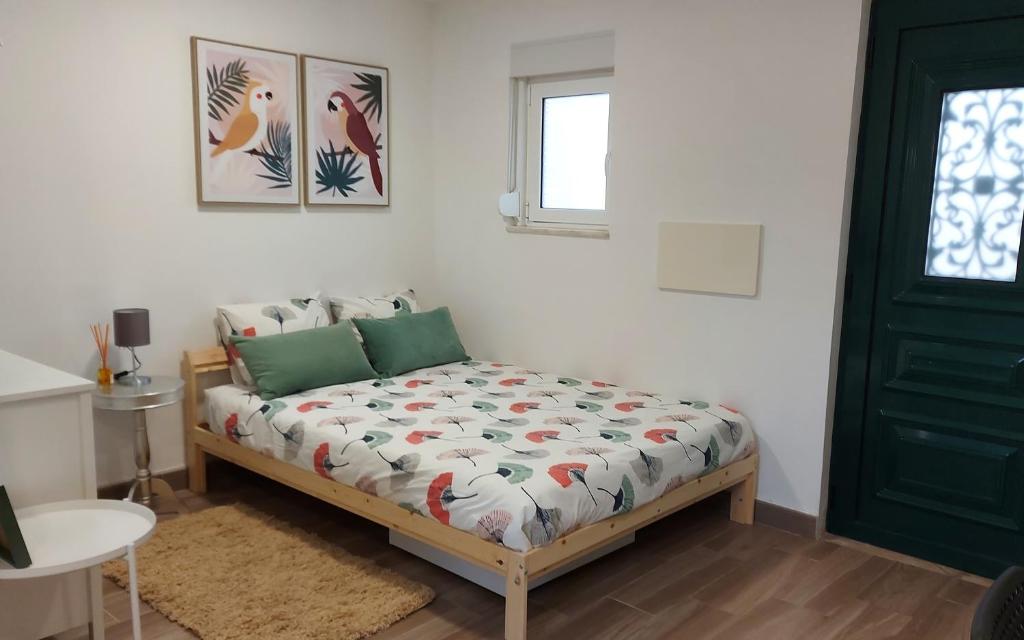 um quarto com uma cama e uma porta verde em Cozy Studio in Central Lisbon em Lisboa