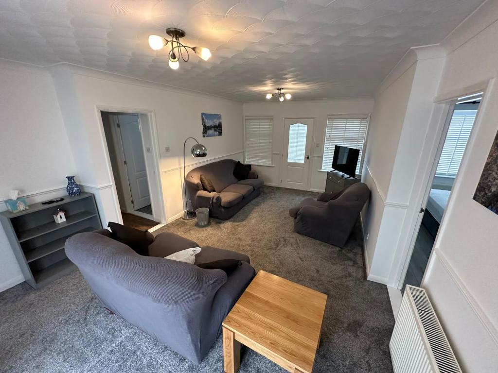 a living room with two couches and a tv at Devon Lodge in Worlingham