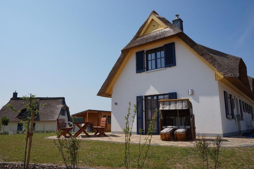 a large white house with a thatched roof at Reethaus "Calappa" in Zierow