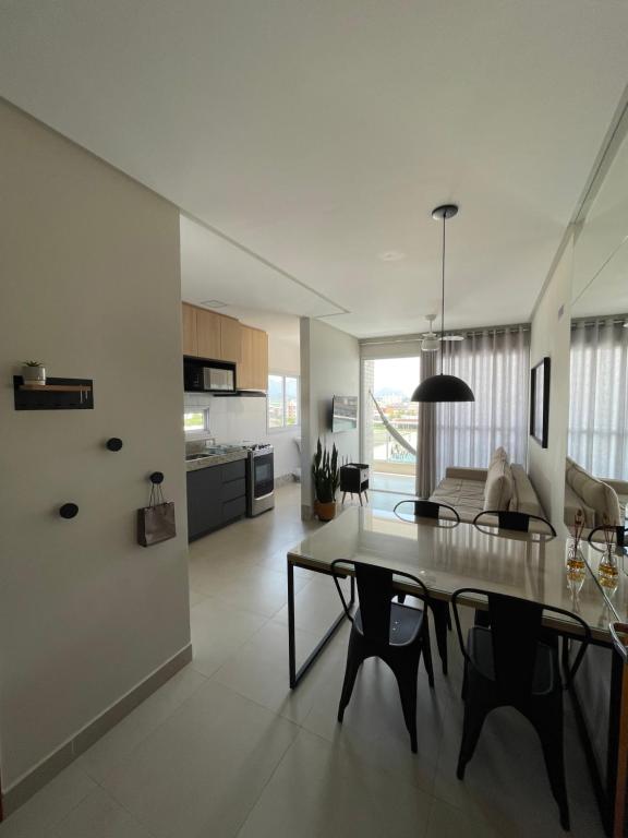 a kitchen and living room with a table and chairs at Apartamento Praia do Morro in Guarapari