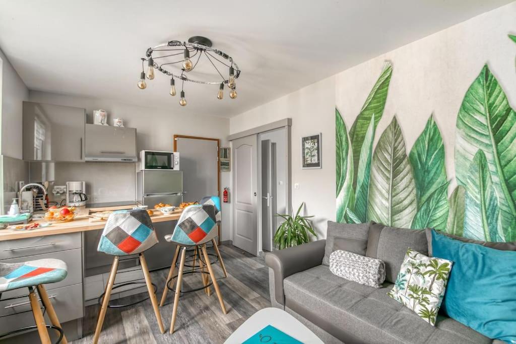 un salon avec un canapé et une cuisine dans l'établissement Naturéa- Saint-Julien-les-villas, à Saint-Julien-les-Villas