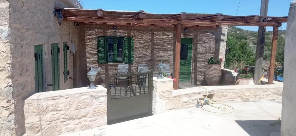 a stone house with a wooden roof and a patio at Villa Drogari in Éxo Apídhion