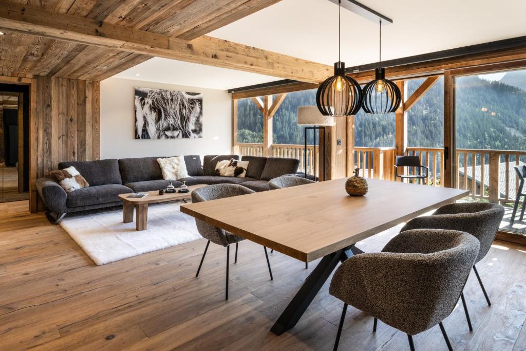 een woonkamer met een houten tafel en stoelen bij Résidence Ancolie in Champagny-en-Vanoise