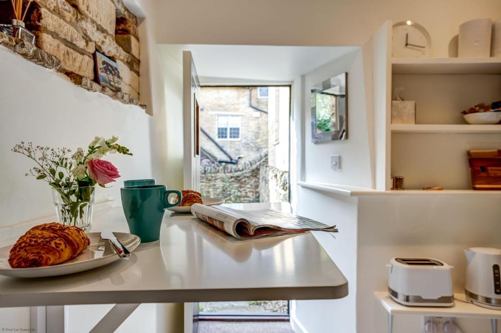 a kitchen with a table with a plate of food on it at The Dovecote in Woodstock