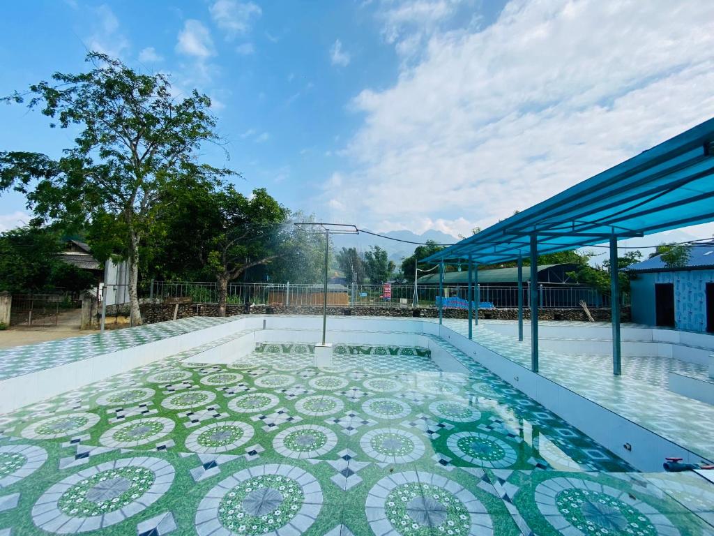 a pool with a mosaic tile floor and a building at Mường Lò Corner in Yên Bái