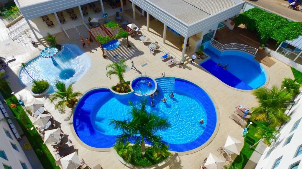 an overhead view of two swimming pools with palm trees at Encontro das Águas Thermas resort in Caldas Novas