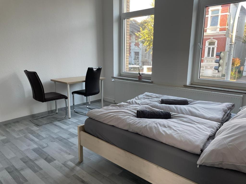 - une chambre avec deux lits, une table et deux chaises dans l'établissement Schöne einfache Ferienwohnung in Oldenburg, à Oldenbourg