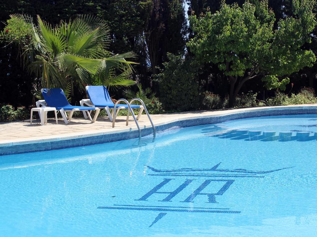 duas cadeiras azuis sentadas ao lado de uma piscina em Rocatel em Canet de Mar
