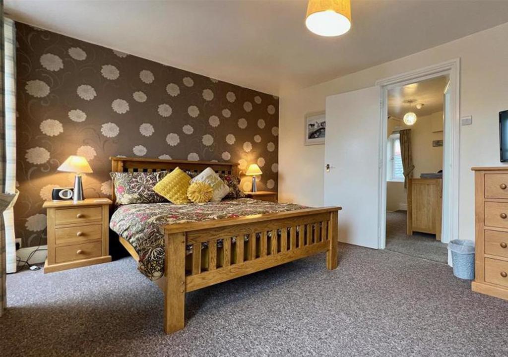 a bedroom with a large wooden bed in a room at Luxury 4 Bedroom Seaside Apartment - Glan Y Werydd House in Barmouth