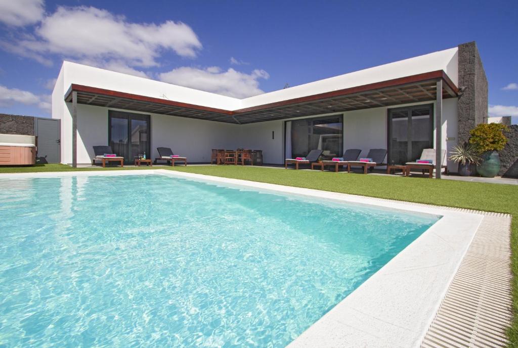 a swimming pool in front of a house at Luxury Los Mojones Villa Short Walk To Old Town Private Heated Pool Villa Los Mojones Angie Puerto Del Carmen in Tías