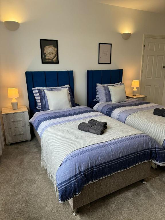 um quarto com 2 camas com cabeceiras azuis em Smart ROOMS Easy access to Central London By Piccadilly Line em New Southgate