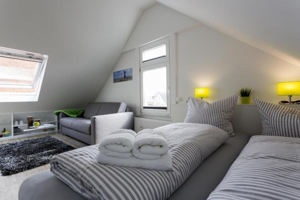 a living room with a couch with two pillows on it at Haus Nordstern Wohnung 5 in Borkum