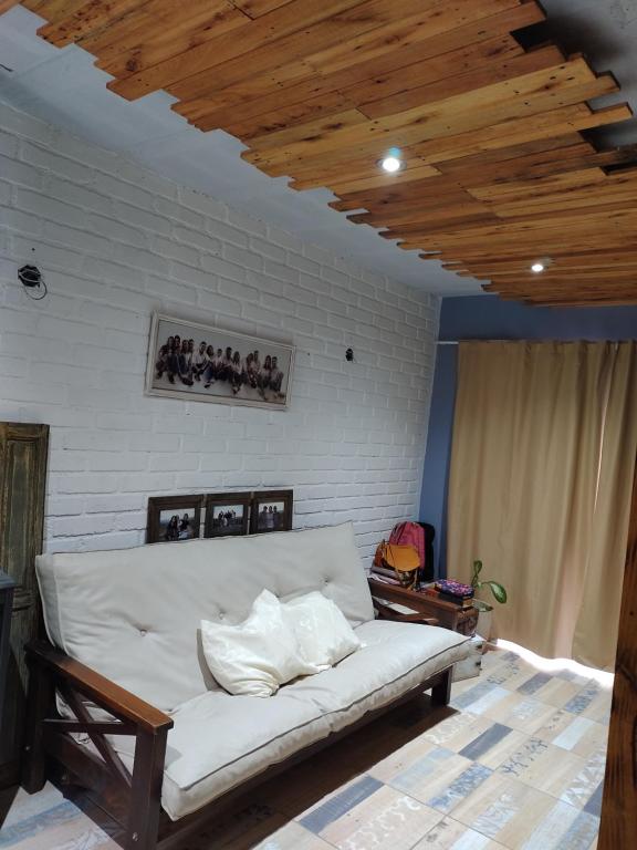 a white couch in a room with a wooden ceiling at Talita Cumi in Villa Santa Cruz del Lago