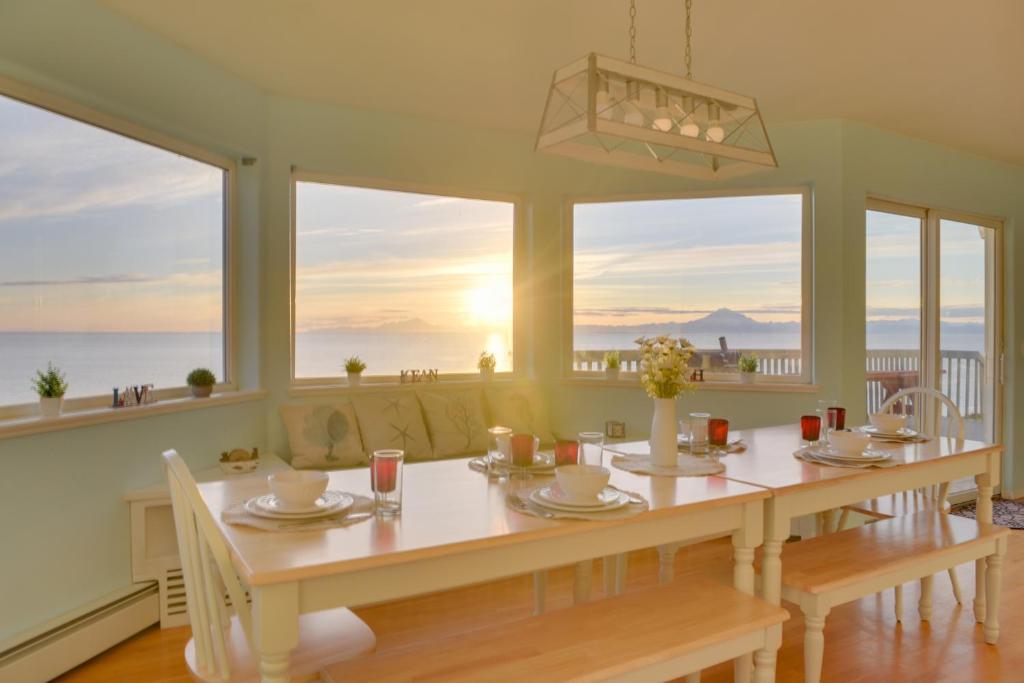 a dining room with a table and views of the ocean at Oceanfront Kenai Villa with Fireplace and Deck in Kenai