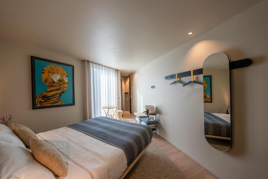 een slaapkamer met een bed en een spiegel bij SUTRooms in Braga