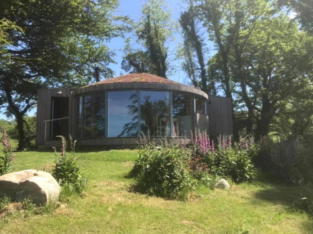 a glass house in a field with a garden at The Roundhouse in Newton Stewart