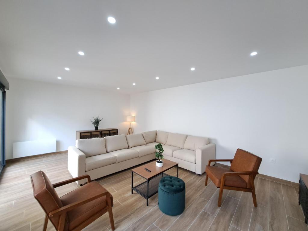 - un salon avec un canapé blanc et des chaises dans l'établissement Abu Dhabi, magnifique maison, à Reims