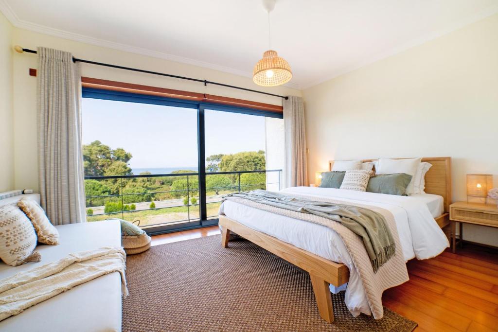a bedroom with two beds and a large window at Magníficos Dias Atlânticos in Moledo