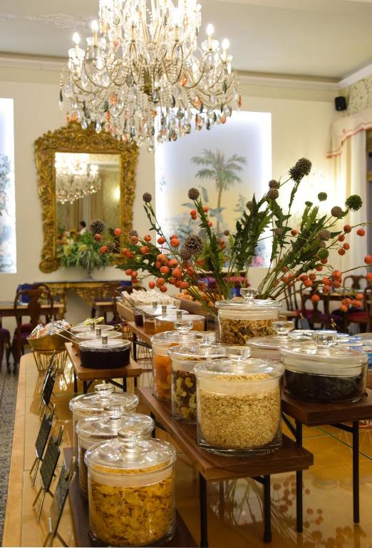 a table with jars of food on it with a chandelier at Palace Hotel in Viareggio