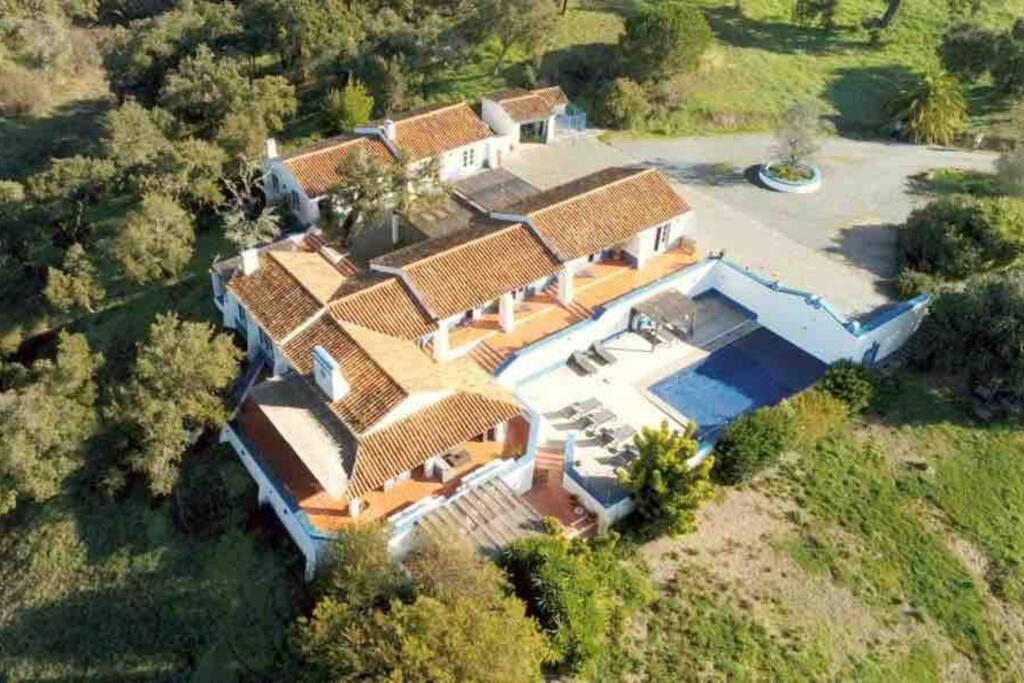 uma vista superior de uma casa grande com um quintal em Monte da Pereirinha a country house with pool and tennis court, 20 mins from beaches em São Bartolomeu da Serra