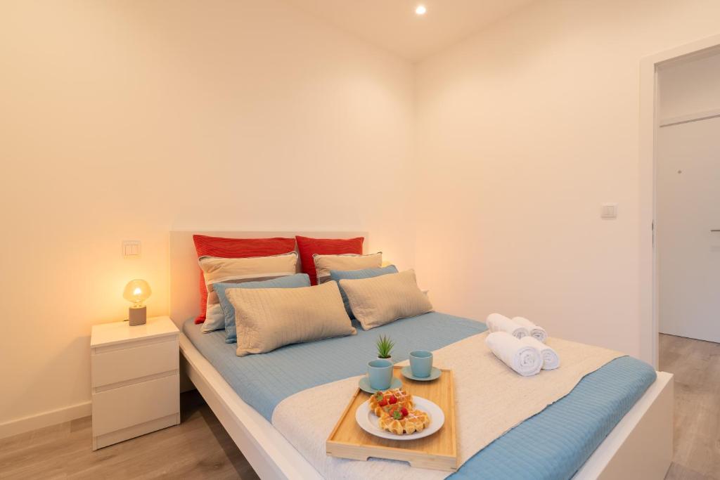 - une chambre avec un lit et un plateau de nourriture dans l'établissement Trendy Spacious Flats - Matosinhos, à Matosinhos