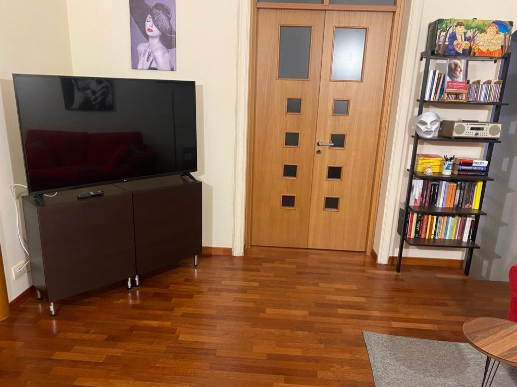 ein Wohnzimmer mit einem Flachbild-TV und einer Tür in der Unterkunft Donna Ada al Duomo in Salerno