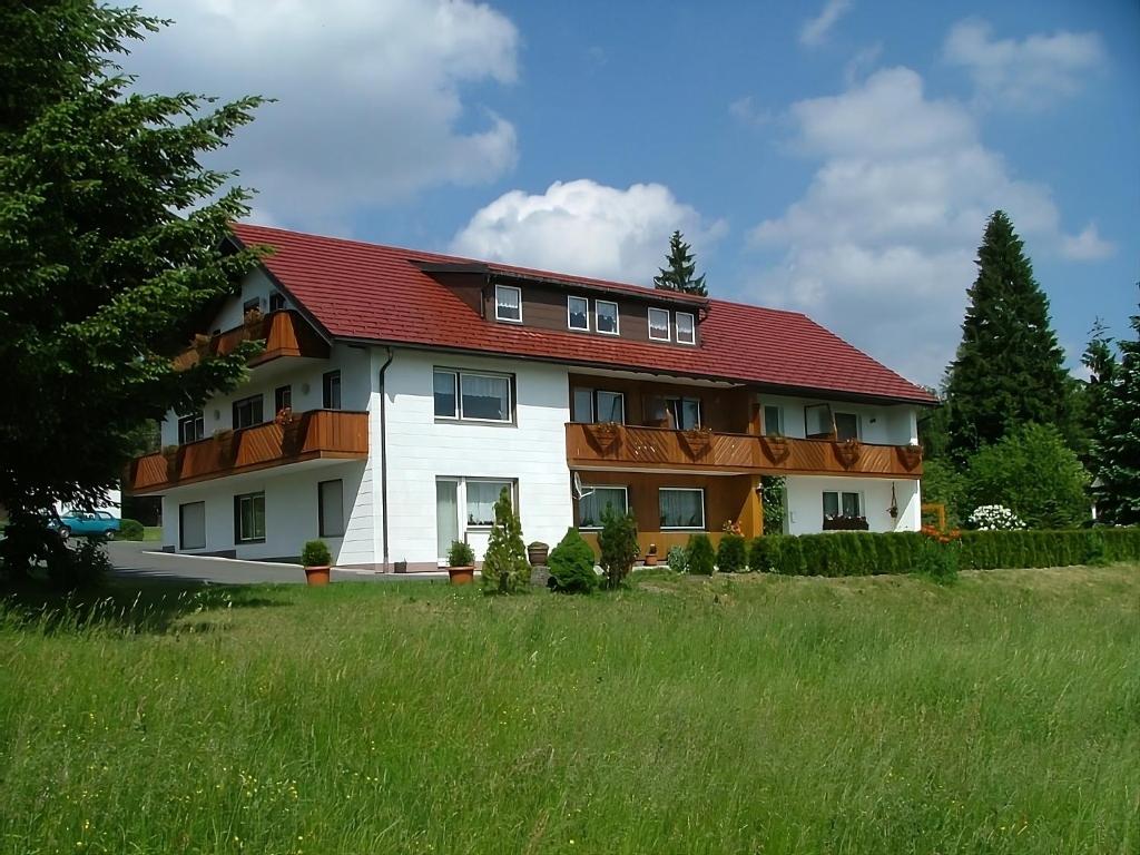 ein großes weißes Haus mit rotem Dach in der Unterkunft Haus Rosenbühl in Warmensteinach